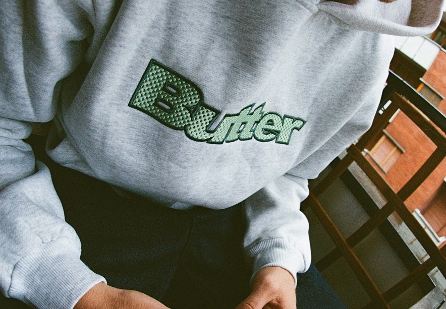 BUTTER GOODS SUDADERA TEXTURE LOGO PULLOVER ASH LOGO MODELO